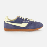 Side view of the AUTRY Windspin Low Suede Sneaker, showcasing a blue suede upper with cream accents and laces, plus a brown rubber sole, all set against a plain white background.