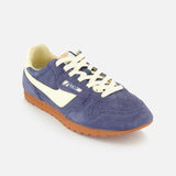 The AUTRY Windspin Low Suede Sneaker features purple suede, white laces and side stripe, a beige lining, and a brown rubber sole for retro 60s style—all set against a crisp white background.