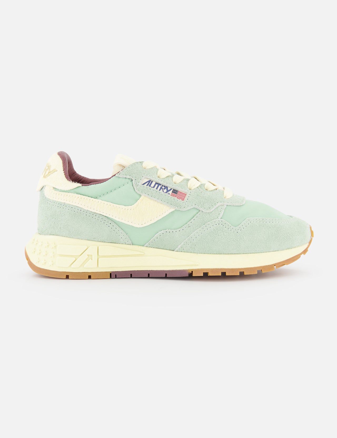 The AUTRY Reelwind Low Sneaker features pastel seafoam green suede, cream accents, a beige sole, and AUTRY branding on the side—shown from the left against a white background—ideal for an active lifestyle.