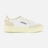 Introducing the AUTRY Medalist Low Gold Heel Sneaker—a white leather shoe inspired by 1980s tennis styles, featuring beige suede accents, a cream sole, and AUTRY’s iconic small American flag logo on the side. This sneaker is elevated with beige laces, a metallic gold heel patch, and unmistakable retro flair.