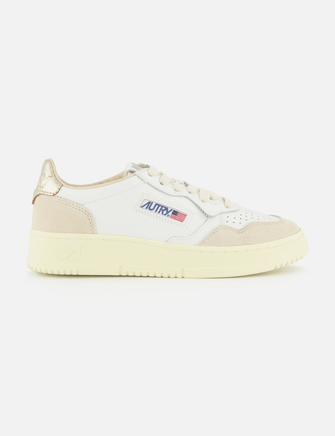 Introducing the AUTRY Medalist Low Gold Heel Sneaker—a white leather shoe inspired by 1980s tennis styles, featuring beige suede accents, a cream sole, and AUTRY’s iconic small American flag logo on the side. This sneaker is elevated with beige laces, a metallic gold heel patch, and unmistakable retro flair.