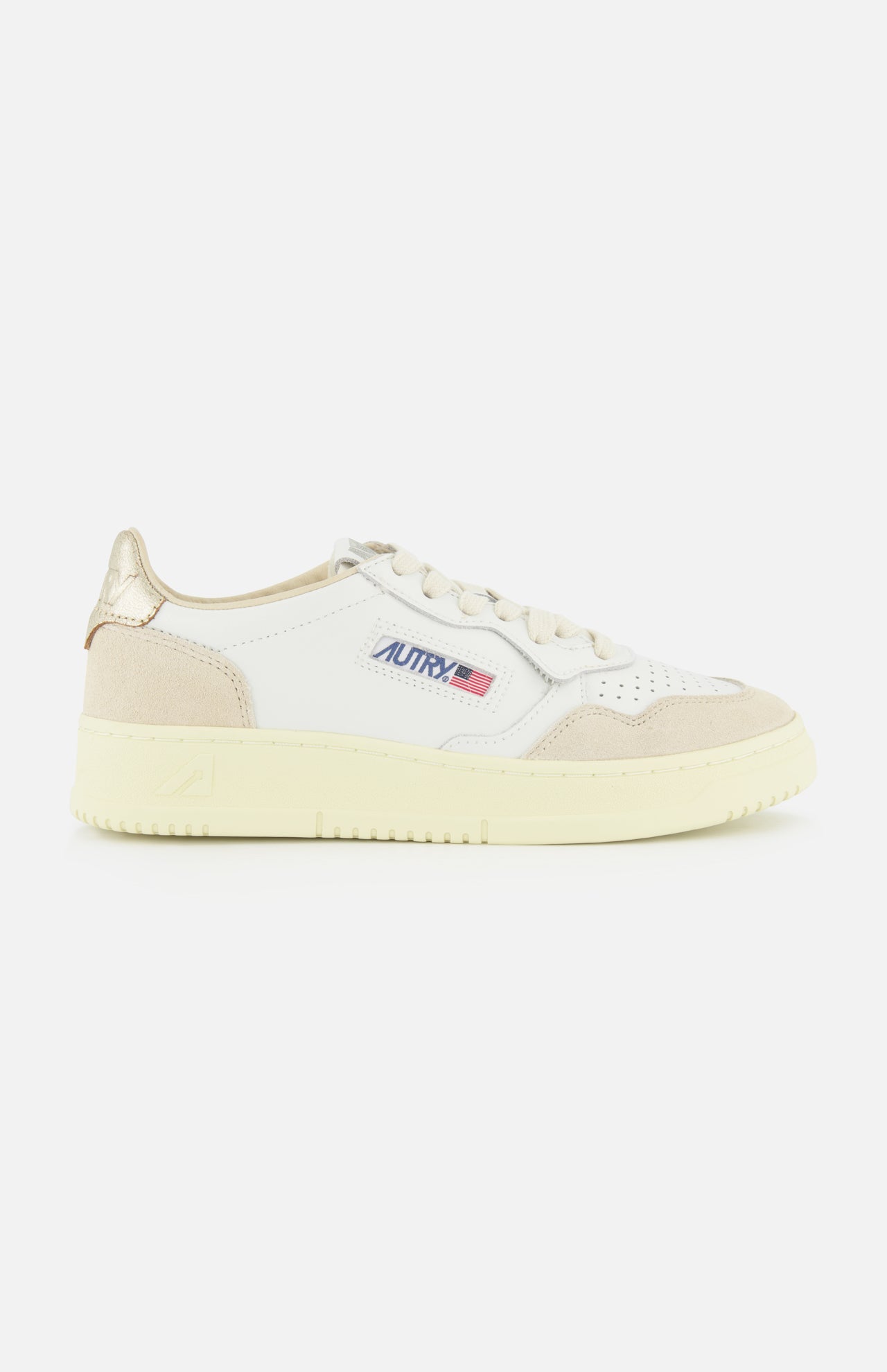 Introducing the AUTRY Medalist Low Gold Heel Sneaker—a white leather shoe inspired by 1980s tennis styles, featuring beige suede accents, a cream sole, and AUTRY’s iconic small American flag logo on the side. This sneaker is elevated with beige laces, a metallic gold heel patch, and unmistakable retro flair.