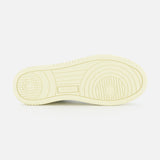 The image shows the sole of the AUTRY Medalist Low Gold Heel Sneaker, featuring circular and linear tread patterns reminiscent of classic 1980s tennis shoes, with a small rectangular section in the center displaying text.