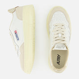 A pair of AUTRY Medalist Low Gold Heel Sneakers, shown from the side and top views, features suede accents, a perforated toe, and the signature American flag logo on the side. These stylish white leather sneakers with beige detailing are inspired by classic 1980s tennis shoes and are set against a crisp white background.