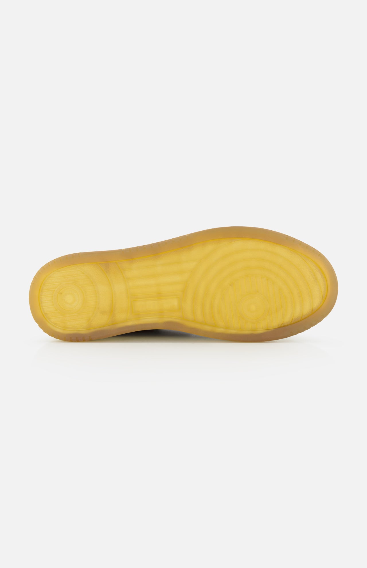 Bottom view of the AUTRY Medalist Low Suede Sneaker with Croco-effect, featuring a yellow rubber sole with textured circular grip patterns reminiscent of 1980s tennis shoes, photographed against a white background.