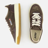 A pair of AUTRY Medalist Low Suede Sneakers with Croco-effect in dark chocolate brown, featuring white laces and gum soles, seen from the side and top against a white background. Inspired by classic 1980s tennis shoes, these sneakers combine vintage charm with contemporary design details.