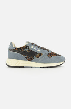 Sure! Here’s a rewritten version using your product data: The AUTRY Reelwind Low Pony Hair Sneaker, featuring gray and leopard-print pony hair uppers, a white sole, brown and black laces, and a blue “Autry” label on the side, is thoughtfully designed for an active lifestyle. Shown against a white background.