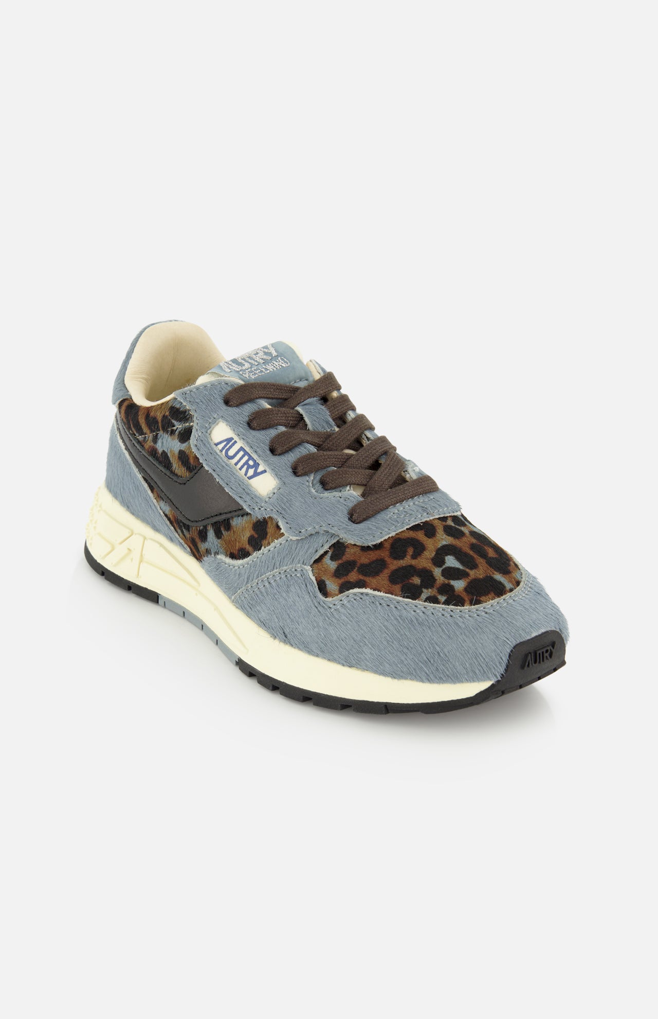 The AUTRY Reelwind Low Pony Hair Sneaker showcases blue and brown panels, leopard print accents, brown laces, a cream-colored midsole, and a black outsole—delivering stylish versatility for an active lifestyle—all displayed against a white background.