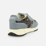 Introducing the AUTRY Reelwind Low Pony Hair Sneaker—a stylish low-top designed for active lifestyles, featuring gray suede and leopard print accents, a cream sole, and AUTRY branding on the heel. Shown from a back side angle against a white background.