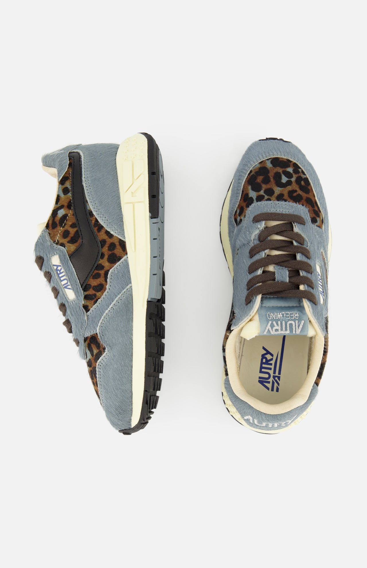 The AUTRY Reelwind Low Pony Hair Sneaker features striking blue-gray uppers with black accents, tan soles, and bold brown leopard print details. Displayed from the side and top against a white background, these stylish low-top sneakers deliver the ideal combination of standout design and comfort for an active lifestyle.