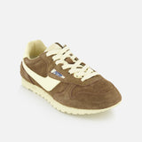 The Autry Windspin Low Brushed Suede Sneaker features a brown and cream 60s-inspired design with a textured suede upper, cream laces and sole, plus a blue and white logo tag on the side, shown against a white background.