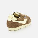 The Autry Windspin Low Brushed Suede Sneaker features dark brown suede, cream accents and sole, and branded heel, shown from the back left against a white background—evoking vintage sneaker charm.