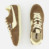 The Autry Windspin Low Brushed Suede Sneaker is shown in brown and cream, with one shoe seen from the side and one from above on a white background. Both feature white laces and vintage-inspired retro details.
