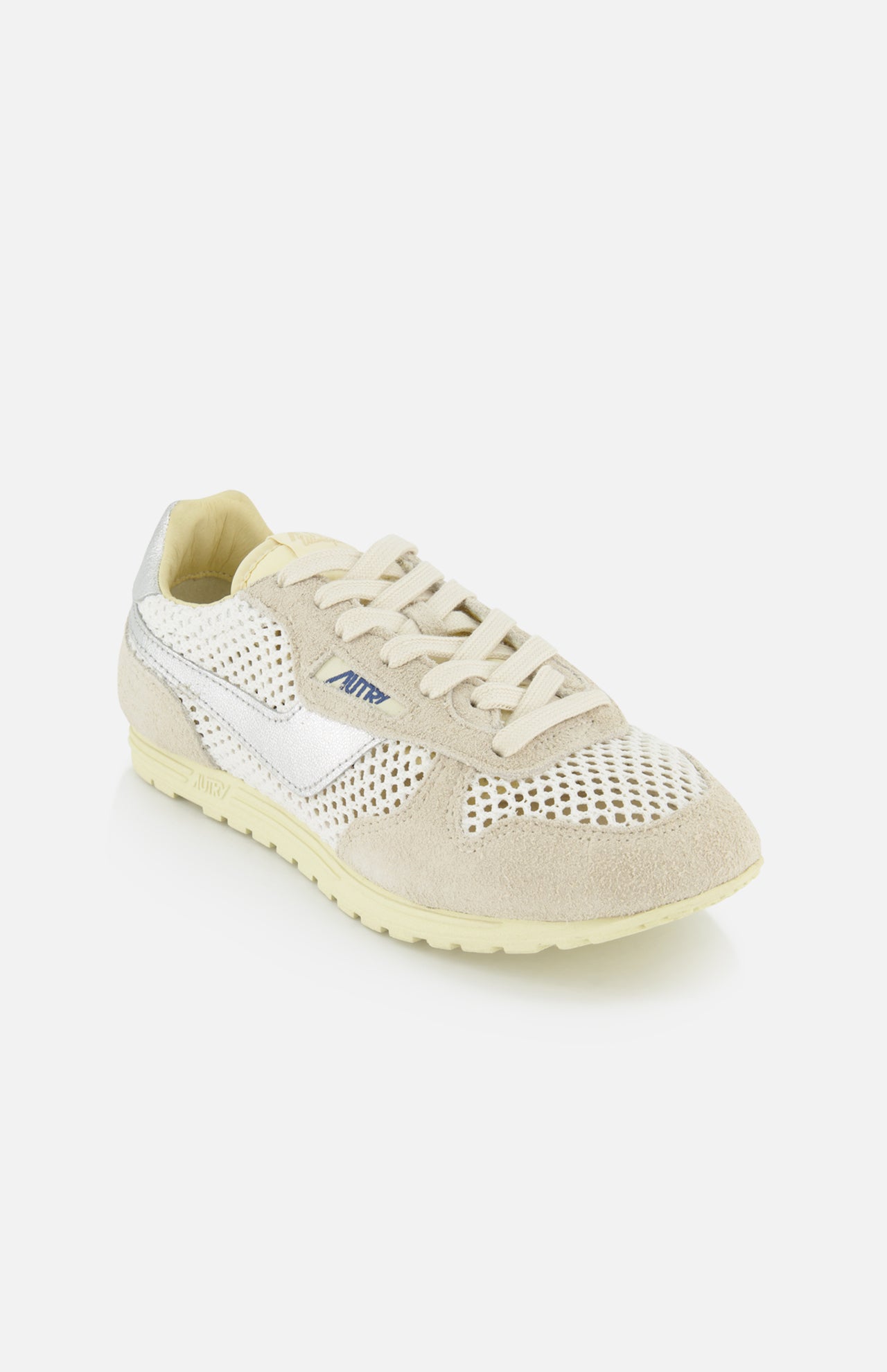 The AUTRY Windspin Low Knit Sneaker features beige and white mesh and suede details, a lace-up front, white textured sole, and AUTRY branding in blue on the side, drawing inspiration from vintage sneakers.