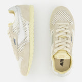 Two cream and beige AUTRY Windspin Low Knit Sneakers with mesh panels, suede accents, laces, textured soles, and blue branding are displayed on a white background—one from the side, the other from above.