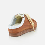 The AUTRY Windspin Leather Mule Sneaker in brown features beige laces and exposed white lining, shown from the back left on a plain white background, blending slip-on ease with vintage flair.