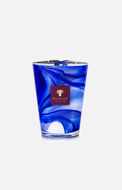 The Atlas Majorelle White Max 24 Candle by BAOBAB COLLECTION features a hand-blown glass vessel with blue and white swirls, an orange blossom scent, and a gold logo on a maroon label.