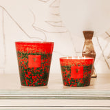 The BAOBAB COLLECTION Arty Flowers Poppies Max 16 Candle adds a decorative touch atop a light dresser, accompanied by a lamp with a round white shade and abstract wall art featuring a large hand outline in the background.