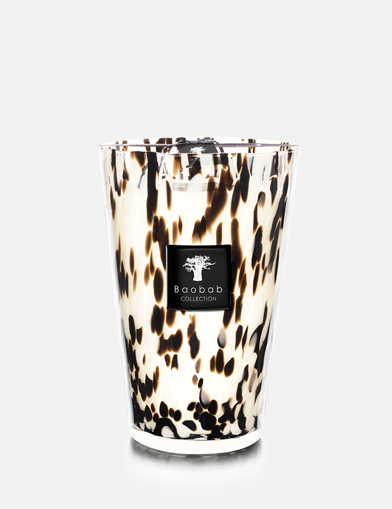 The Pearls Black MAX 35 by BAOBAB COLLECTION is a white hand-blown glass candle featuring black and brown speckles and the brand's label on the front, placed against a plain light gray background.