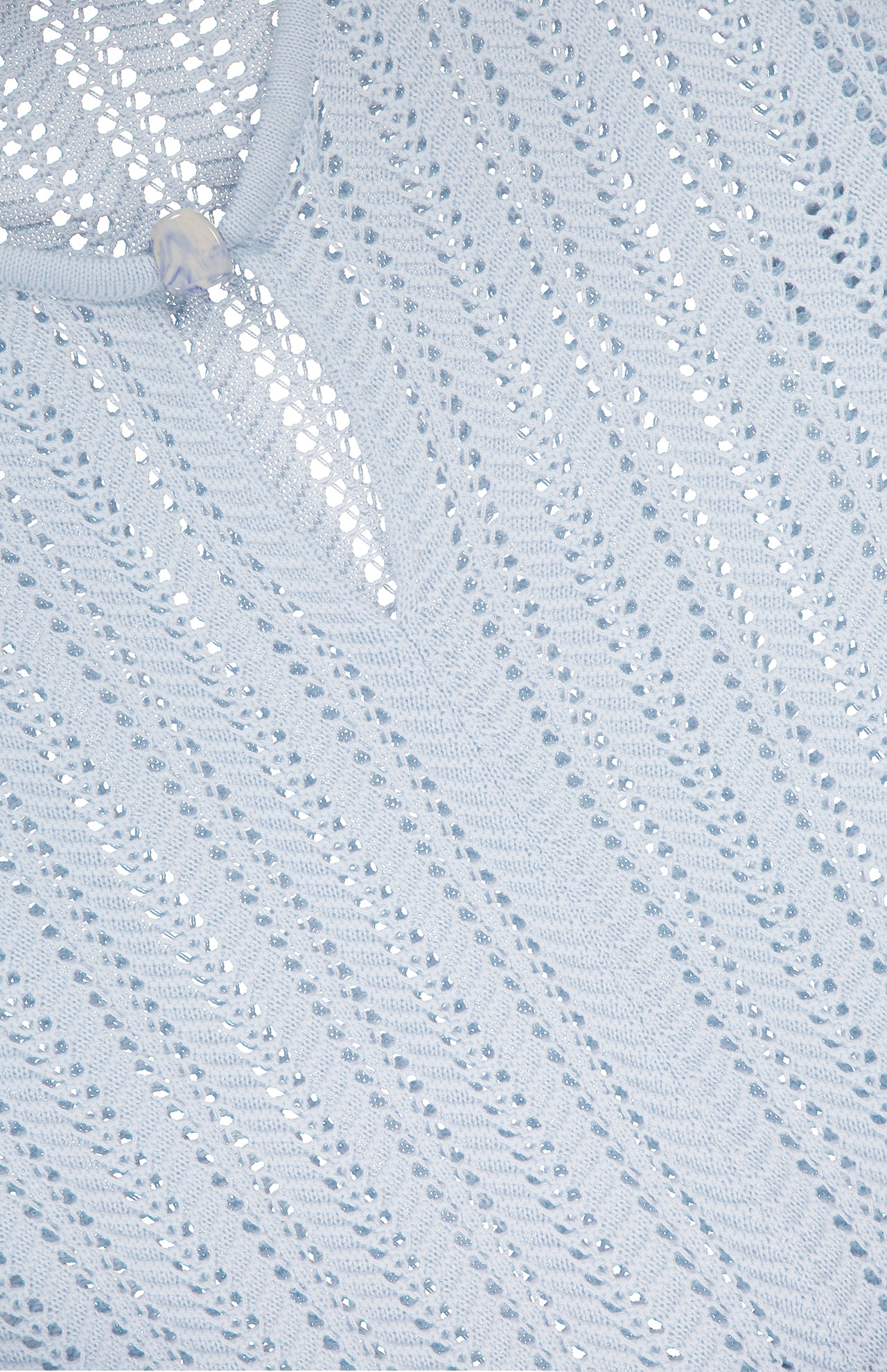 The Lion Sheer Stone Mini Dress by BAOBAB features light blue knitted fabric with shimmering silver sequins and a translucent button at the neckline, making it perfect for destination dressing.