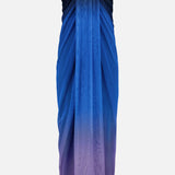 The Lena Strapless Maxi Dress by BAOBAB features a gradient design that shifts from dark navy to light purple, made from flowing fabric with cascading draped details at the front.