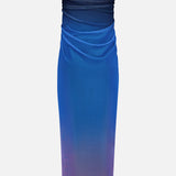 The BAOBAB Lena Strapless Maxi Dress features a ruched, gradient design blending dark navy, vibrant blue, and light purple with cascading detail and subtle draping at the waist and hips.
