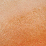 A textured surface features a gradient from light beige to an orange-brown inspired by BAOBAB’s Lola Open Back Maxi Dress, evoking the look of watercolor or a painted wall.