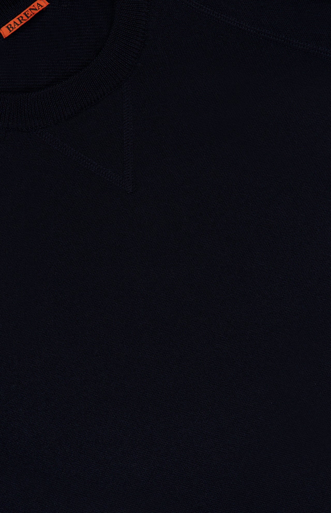 Close-up of the Basilio Crewneck Sweater by BARENA, crafted in Italy from 100% wool in dark navy. The image highlights the neckline and features a small orange BARENA label at the top left corner, showcasing the fabric texture and intricate stitching details.