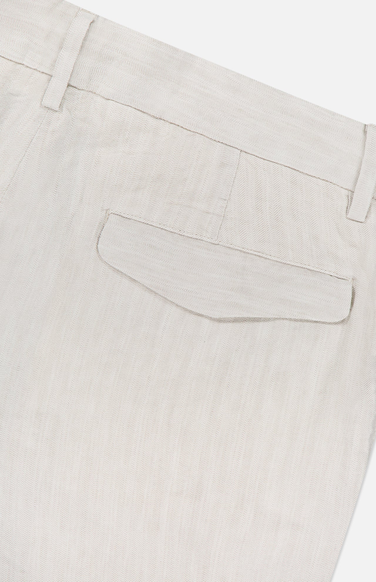 Close-up of the back pocket on BARENA’s Delfo Lisca Herringbone Pants in light beige, featuring a buttoned flap, belt loops, and finely stitched herringbone weave fabric.