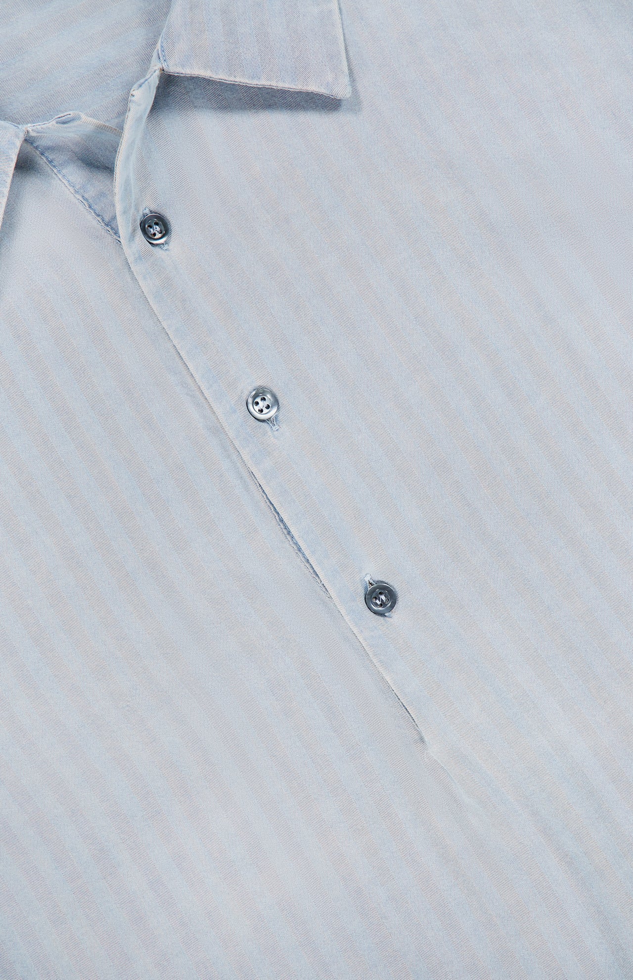 Close-up of the Desmo Button Up Long Sleeve Shirt by BARENA, made in Italy, in light blue cotton, highlighting part of the collar, three buttons, and subtle vertical stripes in the fabric.