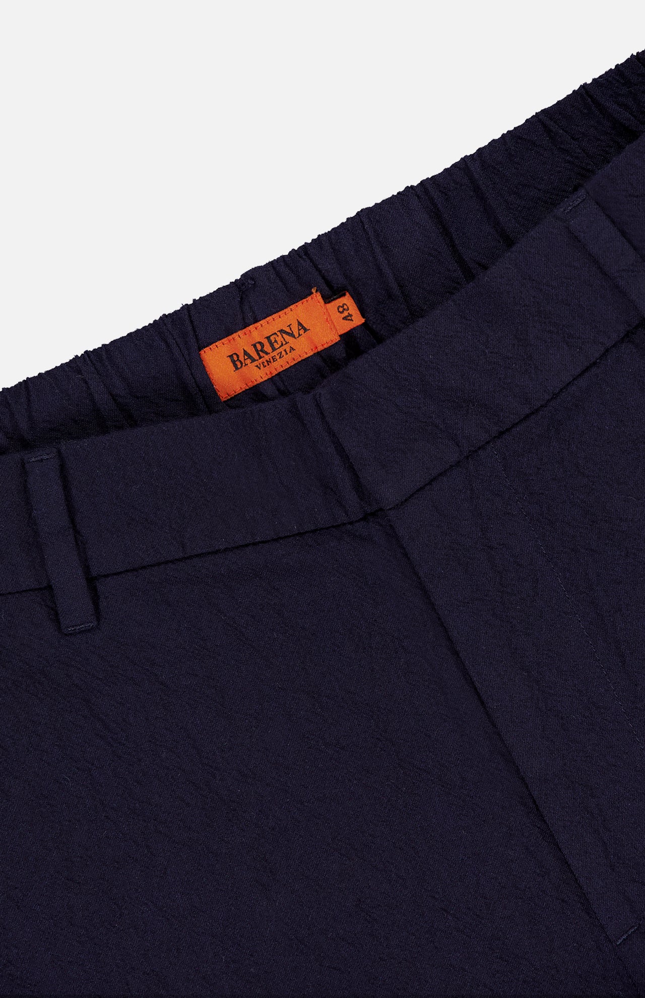 Close-up of Dosana Dandaro Pants by BARENA featuring a navy textured fabric, elastic waistband, belt loops, and an orange Barena Venezia label sewn inside. Premium quality design made in Italy.