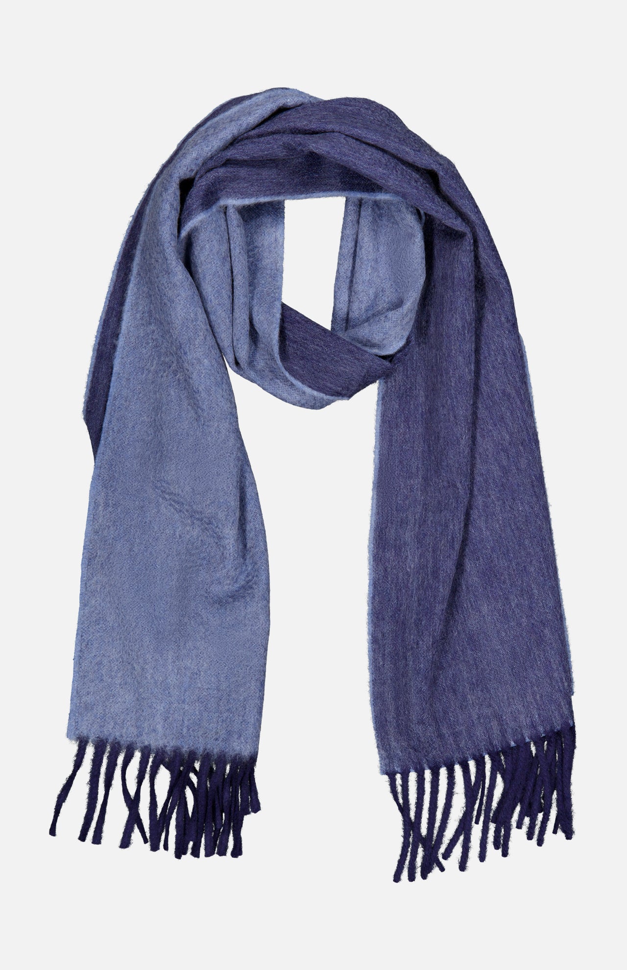 The Arran Reversible Scarf by BEGG & CO is a luxurious cashmere accessory made in Scotland, showcasing two-toned blue hues with light blue on one side and dark blue on the other. Finished with fringe at both ends, the scarf is elegantly displayed laid flat on a white background.