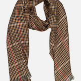 The Washed Kildonan Bryce Scarf by BEGG & CO is crafted in Scotland from soft wool and features a classic checkered pattern in brown, black, and tan with bold red stripes. Fringed ends complete the design, and the scarf is displayed against a white background.