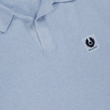 Close-up of the Coast Knitted Waffle Polo Shirt by BELSTAFF in light blue cotton silk piqué, featuring a textured knit, Johnny collar, short button placket, and a small chest patch with the brand logo. Inner label: Silk Cotton.
