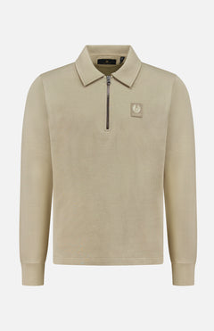 The BELSTAFF Curator Collared 1/4 Zip Sweatshirt is beige with long sleeves, a pointed collar, ribbed cuffs, and an embroidered crest patch on the left chest. Displayed on a plain white background.