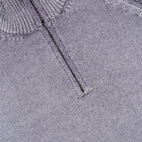 Close-up of the BELSTAFF Garment Dye Aspect Quarter Zip Sweater in light gray, featuring a small silver zipper pull on the quarter-zip collar. Responsibly crafted from sourced wool, the visible texture and stitching showcase its high-quality construction.