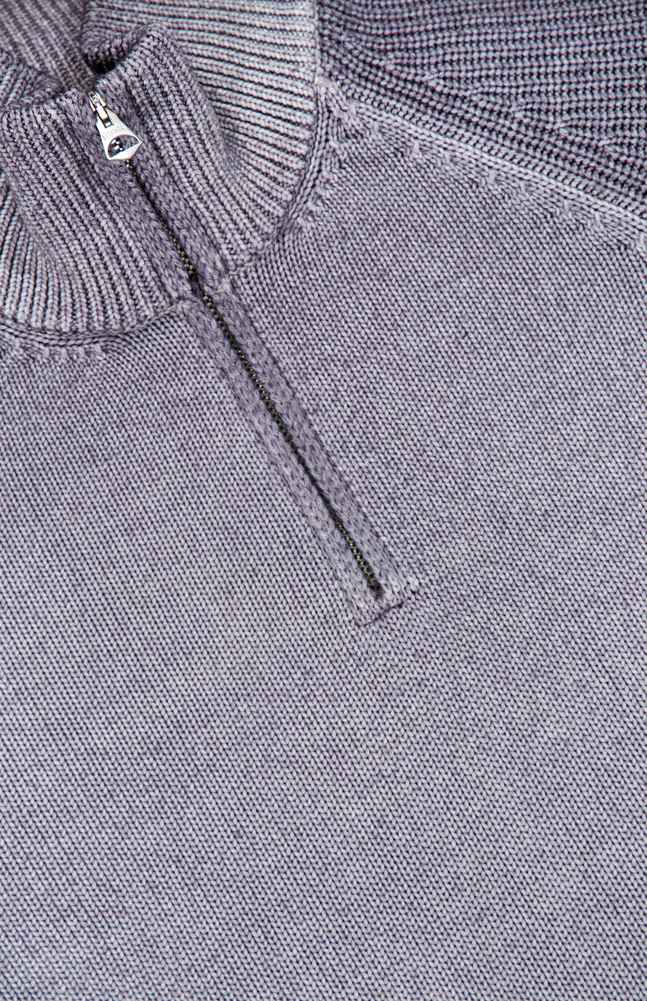 Close-up of the BELSTAFF Garment Dye Aspect Quarter Zip Sweater in light gray, featuring a small silver zipper pull on the quarter-zip collar. Responsibly crafted from sourced wool, the visible texture and stitching showcase its high-quality construction.