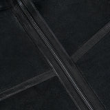 Close-up of the Highland Shearling Jacket by BELSTAFF in black leather, featuring two intersecting leather strips and a visible silver zipper, showcasing classic British heritage design elements.
