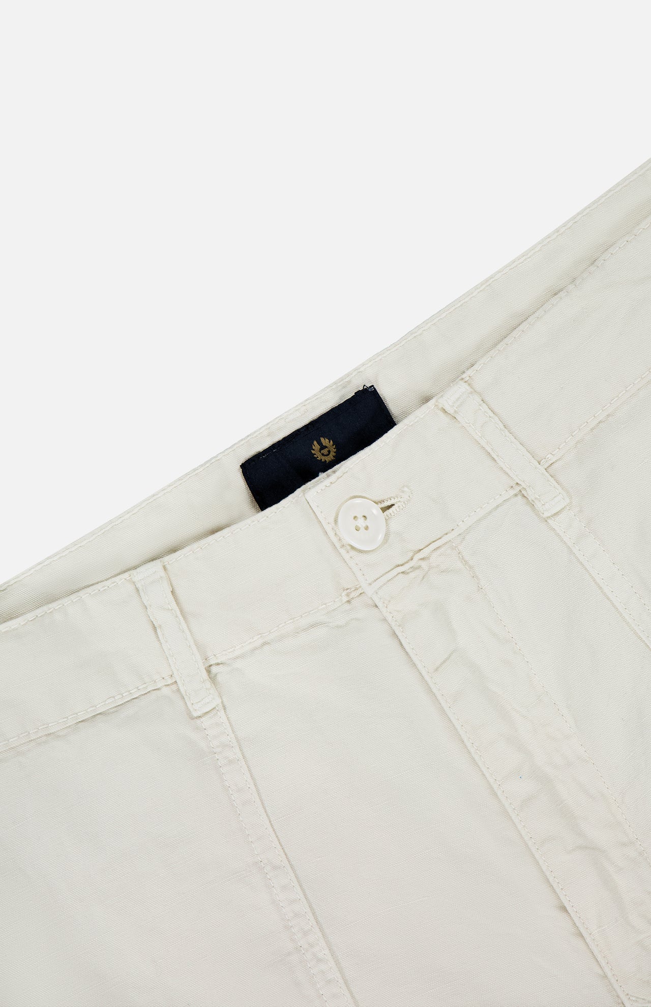 Close-up view of the waistband and upper front of BELSTAFF's Maritime Drawstring Short, featuring off-white cotton linen fabric, a button closure, visible belt loops, and a black label inside the waistband.