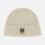 The BELSTAFF Watch Beanie Hat is a cream-colored, ribbed knit lambswool beanie with a folded cuff and a rectangular Belstaff logo patch on the front—a must-have for your cold-weather accessory lineup.