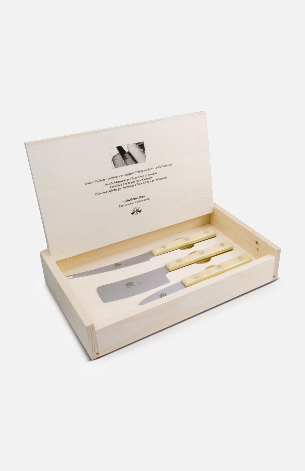 A wooden gift box from Berti Cutlery with its lid open reveals three La Ceremony Dei Formaggi cheese knives with light handles arranged inside; the lid’s interior features printed text and a small image.