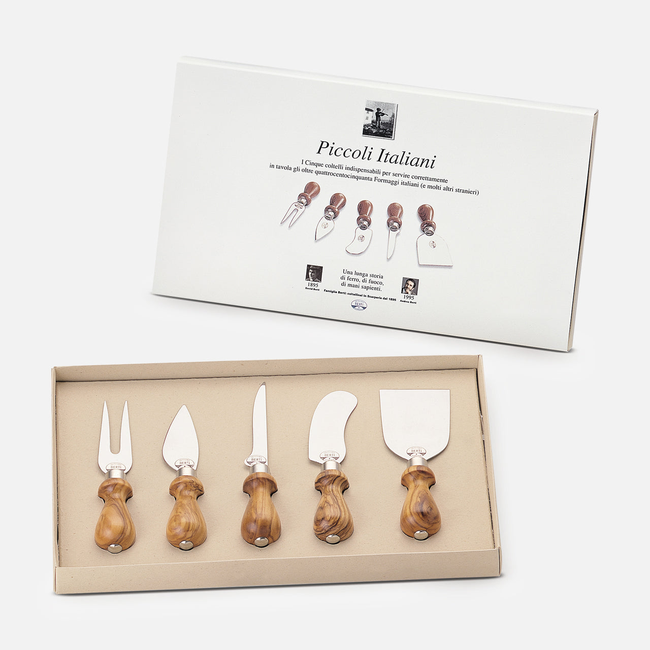 A boxed set of five Little Italians Cutting Cheese Knives by Berti Cutlery, each with olive wood handles, is displayed before its packaging. The box shows images and names of each handmade Italian knife and fork included.