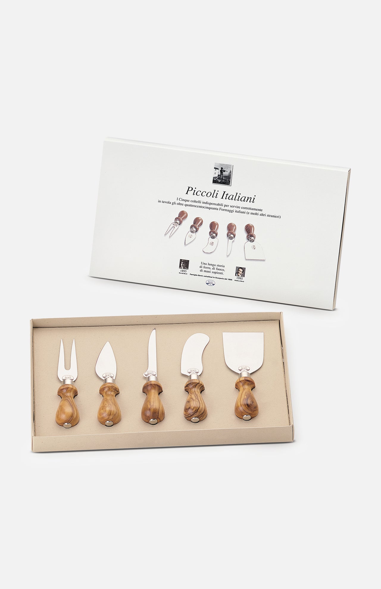 A boxed set of five Little Italians Cutting Cheese Knives by Berti Cutlery, each with olive wood handles, is displayed before its packaging. The box shows images and names of each handmade Italian knife and fork included.