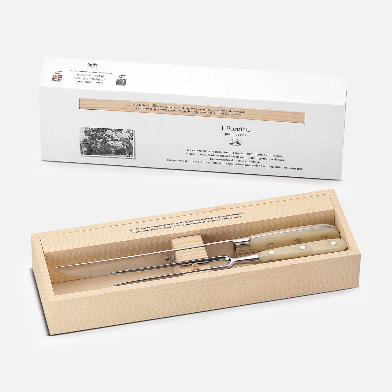 The Berti Cutlery Roast Knives Kit features a handmade Italian carving knife and fork with light handles, elegantly boxed in a wooden case and presented with a white cardboard sleeve.