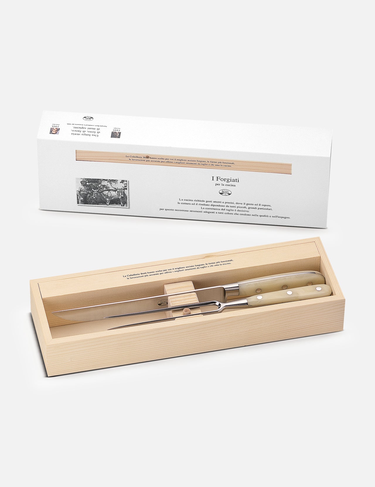 The Berti Cutlery Roast Knives Kit features a handmade Italian carving knife and fork with light handles, elegantly boxed in a wooden case and presented with a white cardboard sleeve.