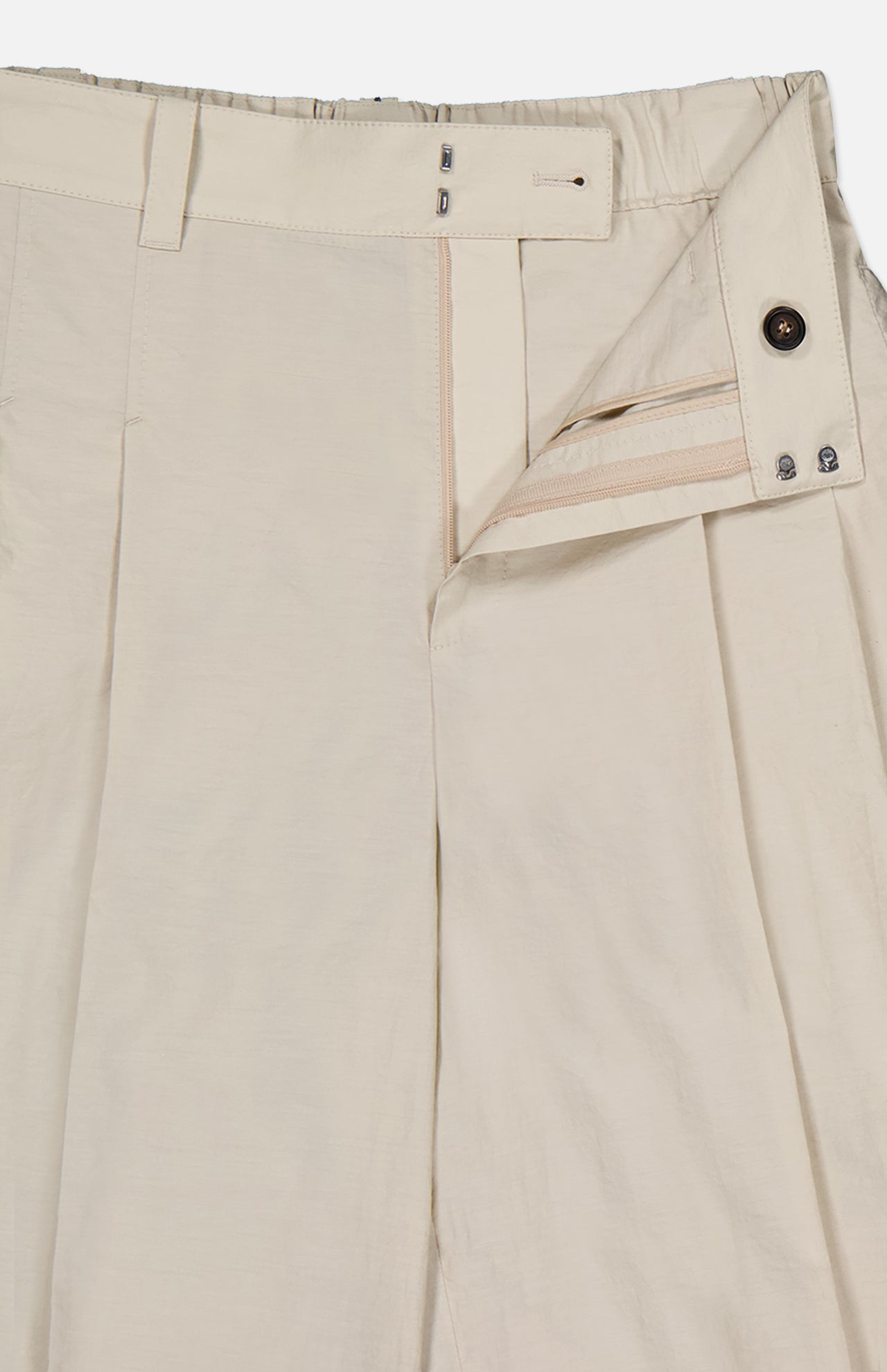 A close-up of BRUNELLO CUCINELLI's Cotton Poplin Deep Pleat A-Line Pant in light beige, featuring an open waistband, button and hook-and-bar closure, inner waistband details, and belt loops—expertly crafted in Italy.