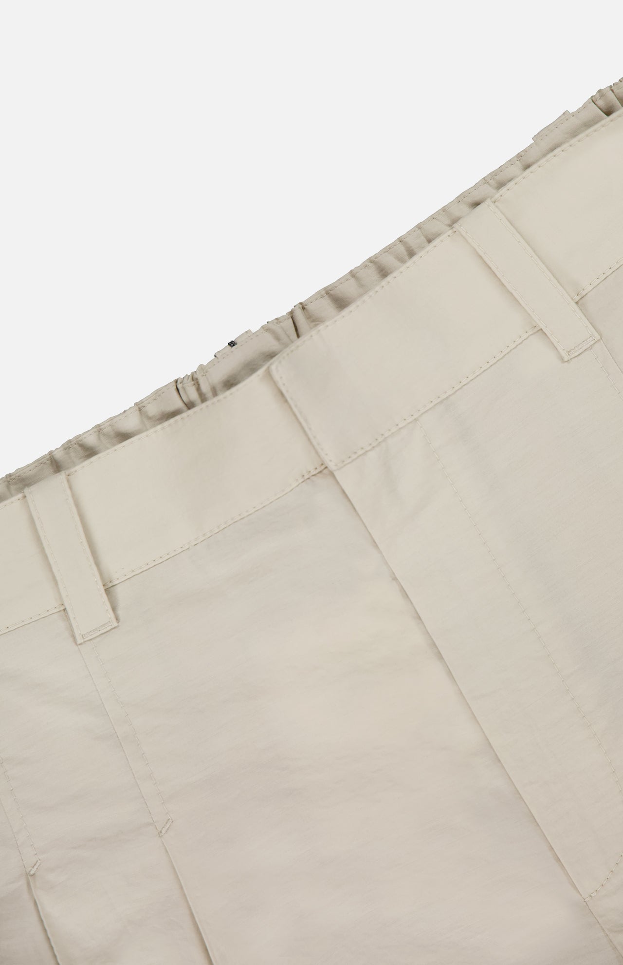Close-up of the waistband and upper section of BRUNELLO CUCINELLI Cotton Poplin Deep Pleat A-Line Pant in beige, featuring belt loops and an elasticated waistband, shown against a plain white background.