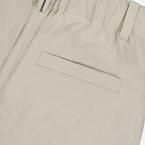 Close-up of the back of BRUNELLO CUCINELLI's Cotton Poplin Deep Pleat A-Line Pant in beige, highlighting the elastic waistband, belt loop, and single welt pocket.