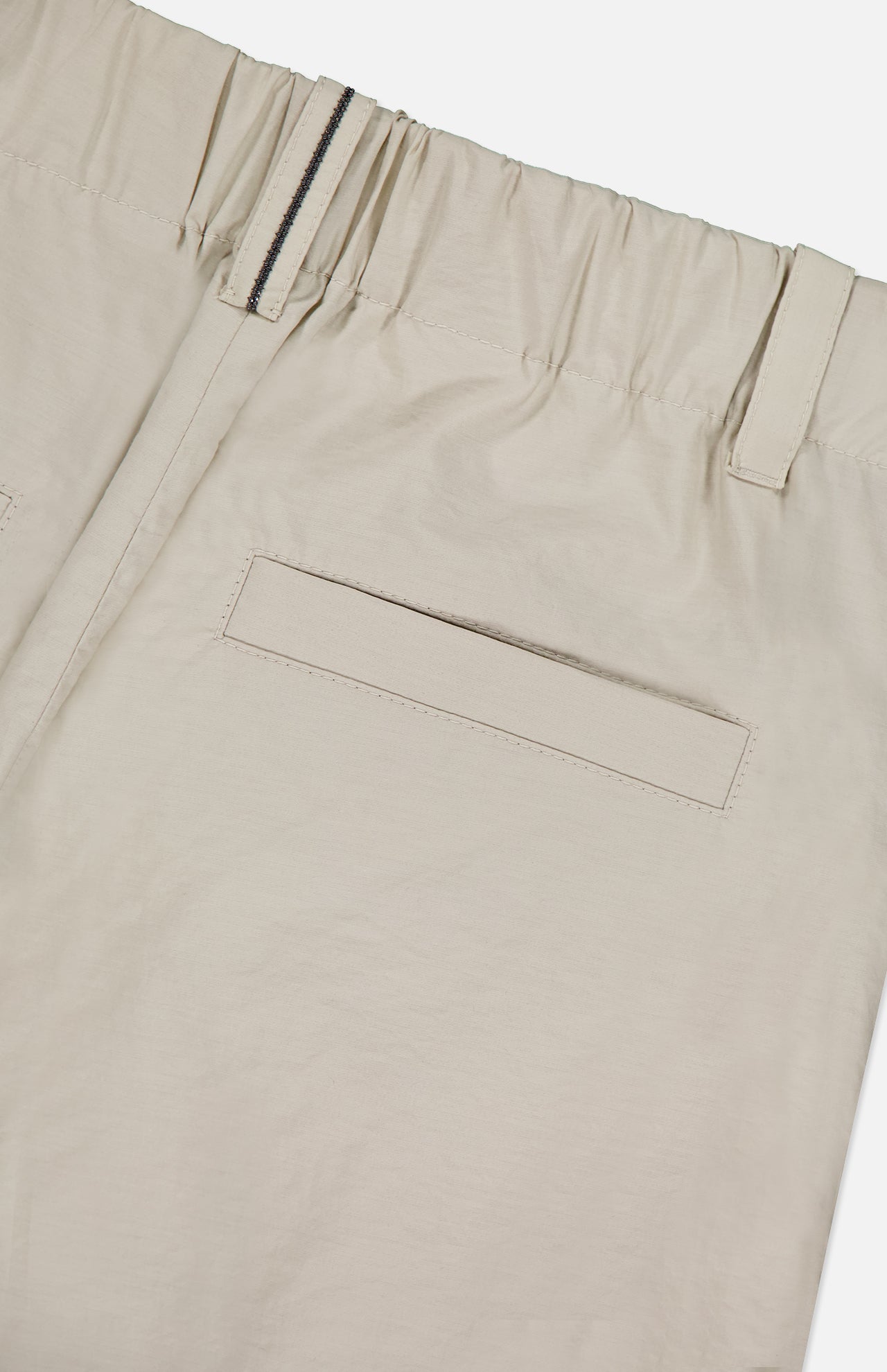 Close-up of the back of BRUNELLO CUCINELLI's Cotton Poplin Deep Pleat A-Line Pant in beige, highlighting the elastic waistband, belt loop, and single welt pocket.