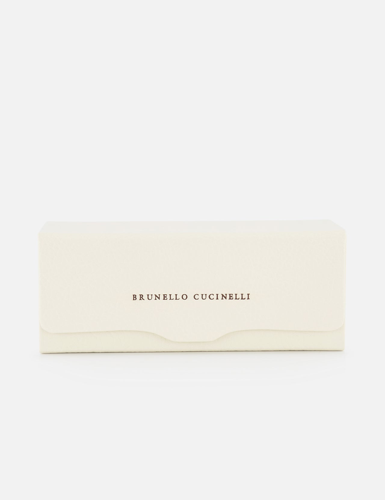 The Leather Glasses Case by BRUNELLO CUCINELLI features cream-colored rectangular leather with the brand’s name in brown lettering on the front, shown against a white background.